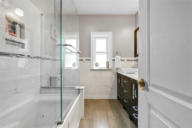 full bath featuring vanity, tile walls, tile patterned flooring, and a combined bath / shower with jetted tub