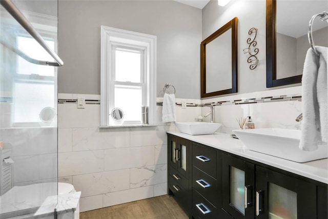 bathroom featuring double vanity, a healthy amount of sunlight, and a sink