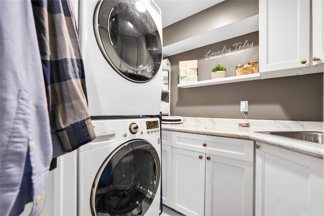 clothes washing area with cabinet space and stacked washer and dryer