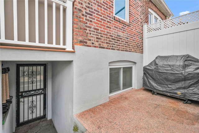 entrance to property featuring brick siding and stucco siding