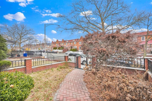 view of yard featuring a fenced front yard, a residential view, and a gate