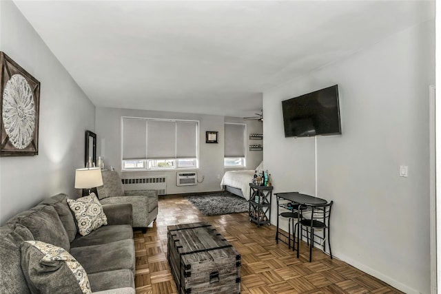 living area with radiator, an AC wall unit, and a ceiling fan