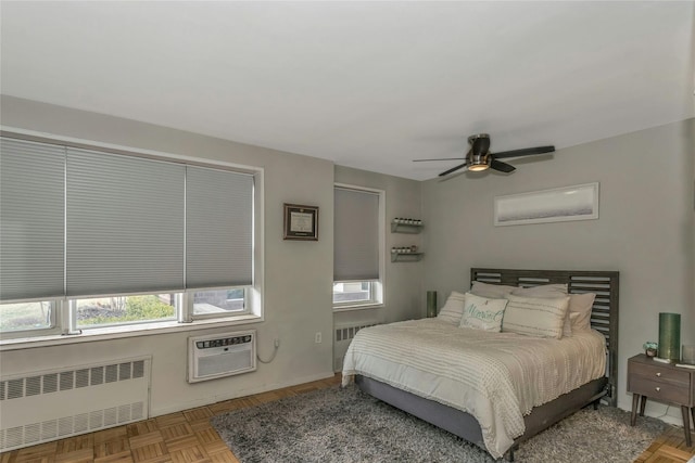 bedroom featuring cooling unit, a wall mounted air conditioner, radiator heating unit, and a ceiling fan