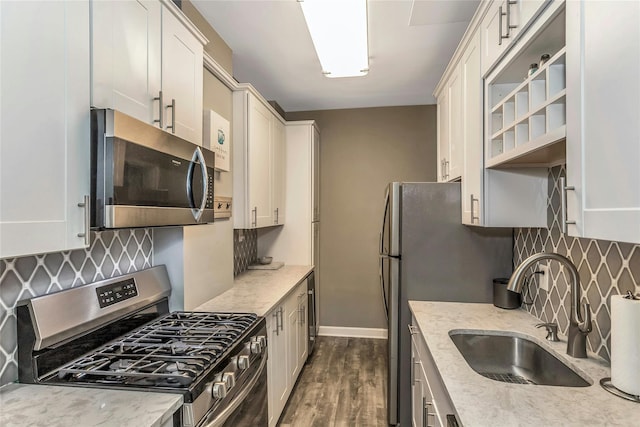 kitchen with dark wood finished floors, tasteful backsplash, appliances with stainless steel finishes, and a sink