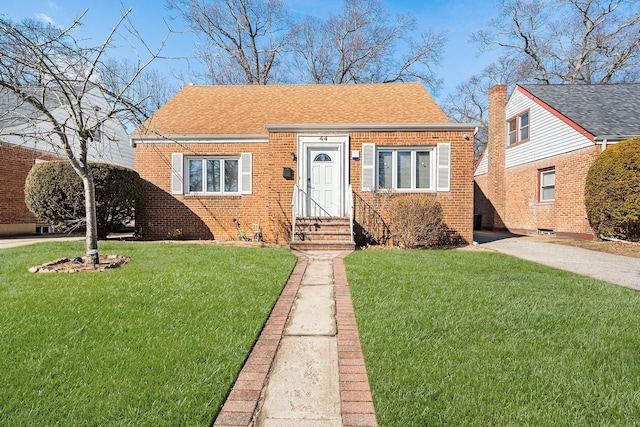 bungalow-style house featuring brick siding, a shingled roof, and a front lawn