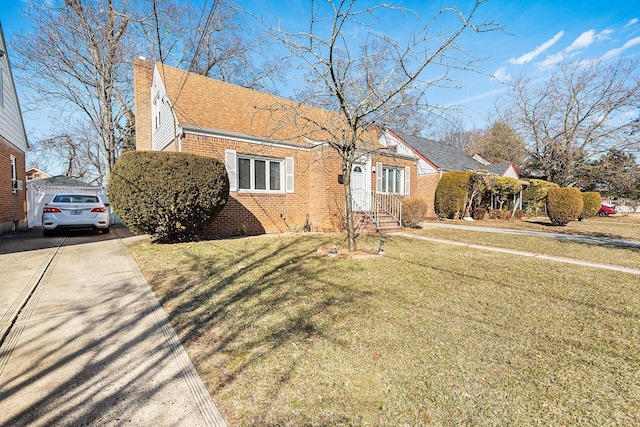 bungalow-style home with a front lawn, concrete driveway, a shingled roof, brick siding, and a chimney