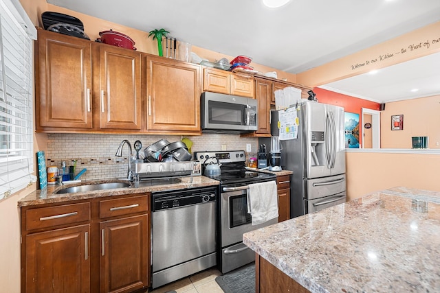 kitchen featuring a sink, brown cabinets, tasteful backsplash, and appliances with stainless steel finishes