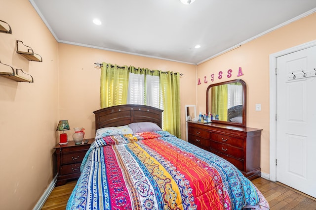 bedroom with crown molding, wood finished floors, and baseboards