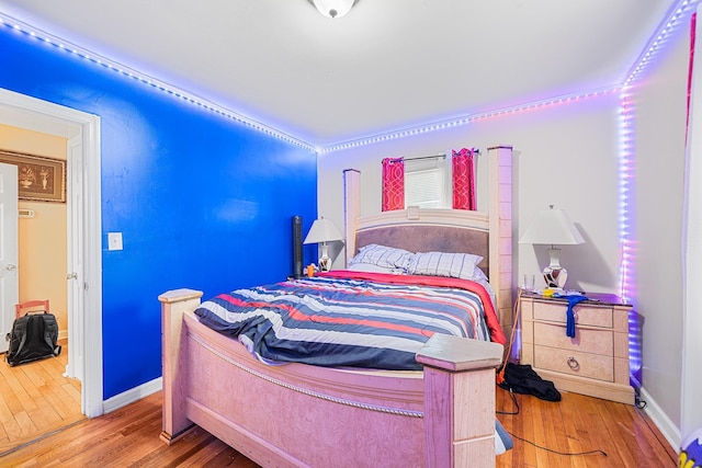 bedroom with baseboards and wood finished floors