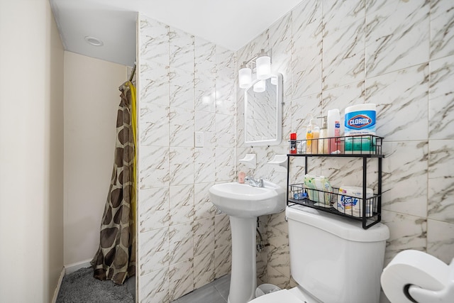 bathroom with a shower with shower curtain, tile walls, and toilet