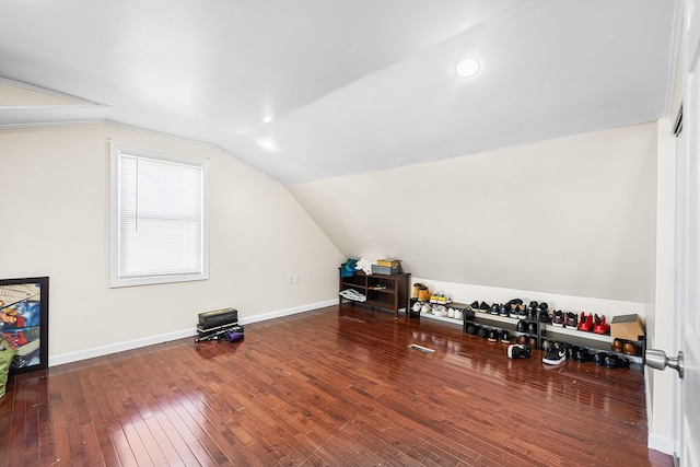 interior space with vaulted ceiling, baseboards, and wood-type flooring