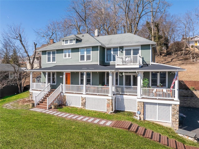 view of front of house with a front yard, a balcony, covered porch, and a chimney