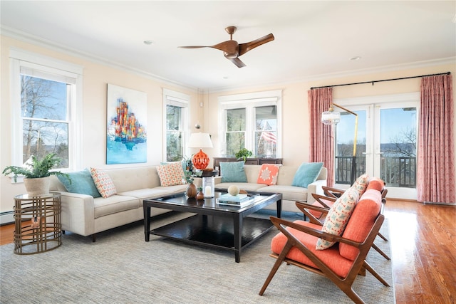 living room featuring wood finished floors, a ceiling fan, and ornamental molding