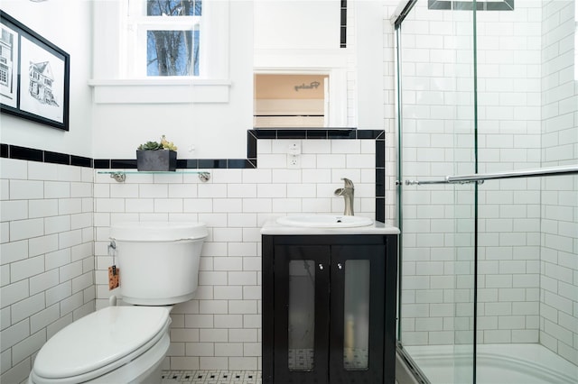 bathroom featuring toilet, tile walls, vanity, and a tile shower