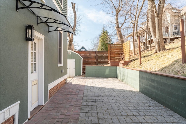 view of patio / terrace featuring a shed, an outdoor structure, and fence