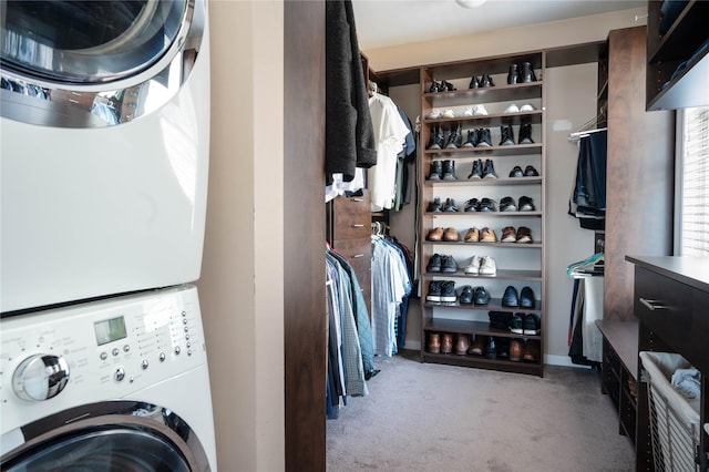 clothes washing area with laundry area, stacked washer / dryer, and carpet