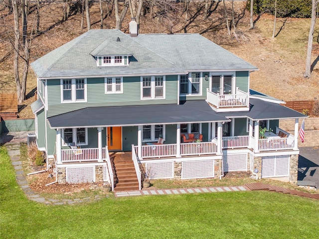 view of front of home with a balcony, a porch, stairs, and a front yard