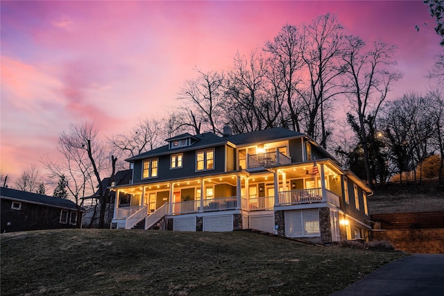 view of front facade with covered porch, a front lawn, a balcony, and ceiling fan