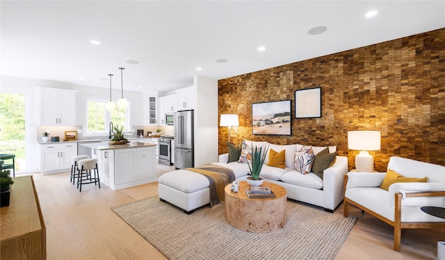 living area with light wood finished floors and recessed lighting