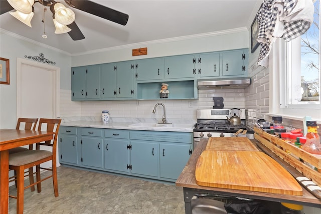 kitchen featuring a ceiling fan, a sink, light countertops, under cabinet range hood, and stainless steel gas stove