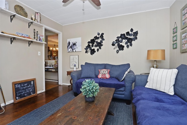 living room with wood finished floors, ornamental molding, and ceiling fan with notable chandelier