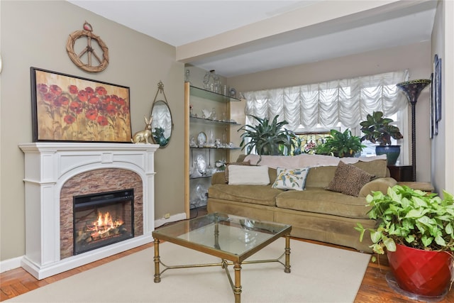 living area featuring a fireplace, baseboards, and wood finished floors