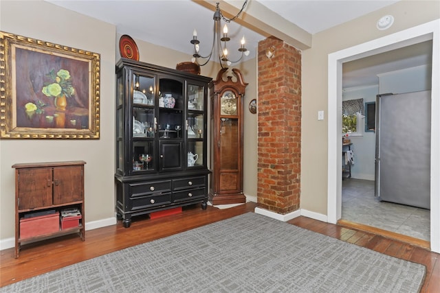 interior space with baseboards, an inviting chandelier, and hardwood / wood-style flooring