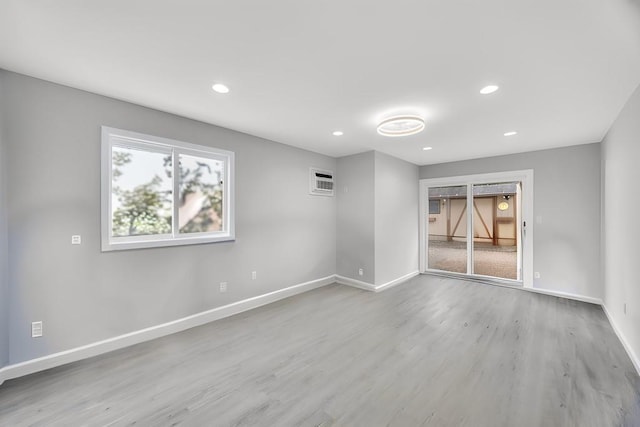 unfurnished room featuring recessed lighting, wood finished floors, and baseboards