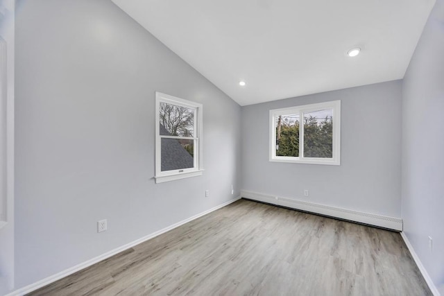 spare room featuring a baseboard radiator, recessed lighting, vaulted ceiling, wood finished floors, and baseboards