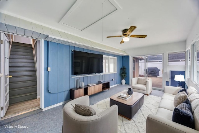 living area featuring attic access, carpet flooring, baseboards, and stairs