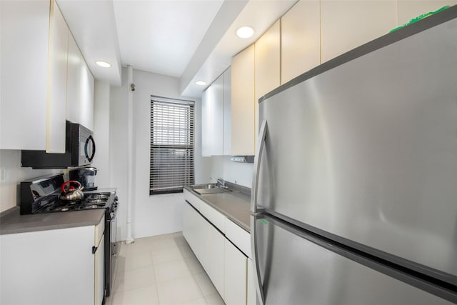 kitchen with stainless steel appliances, dark countertops, a sink, and recessed lighting