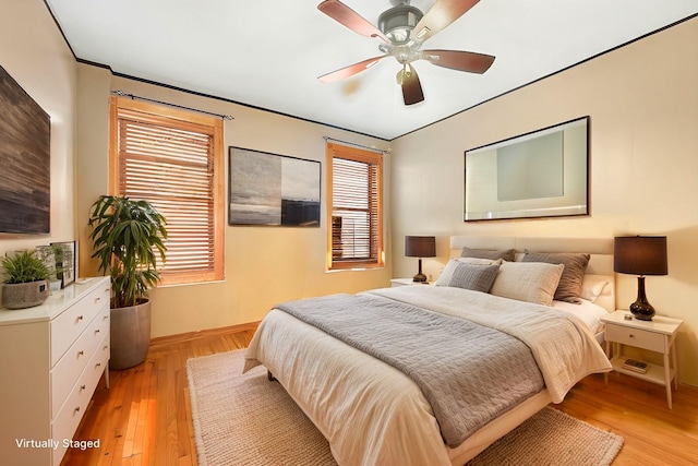 bedroom featuring ceiling fan, light wood finished floors, and baseboards