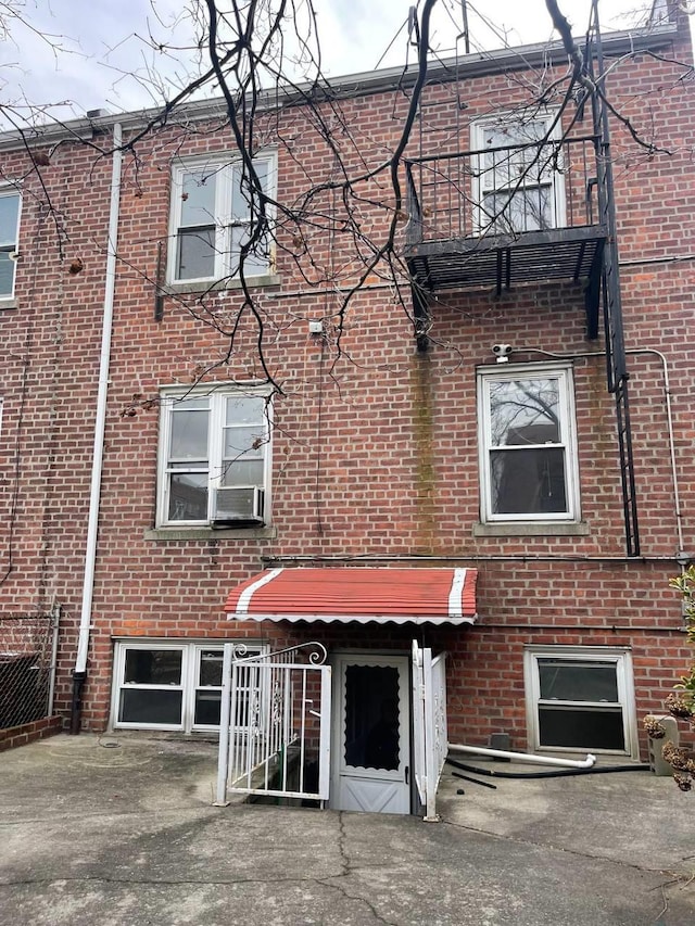 townhome / multi-family property featuring brick siding and a balcony