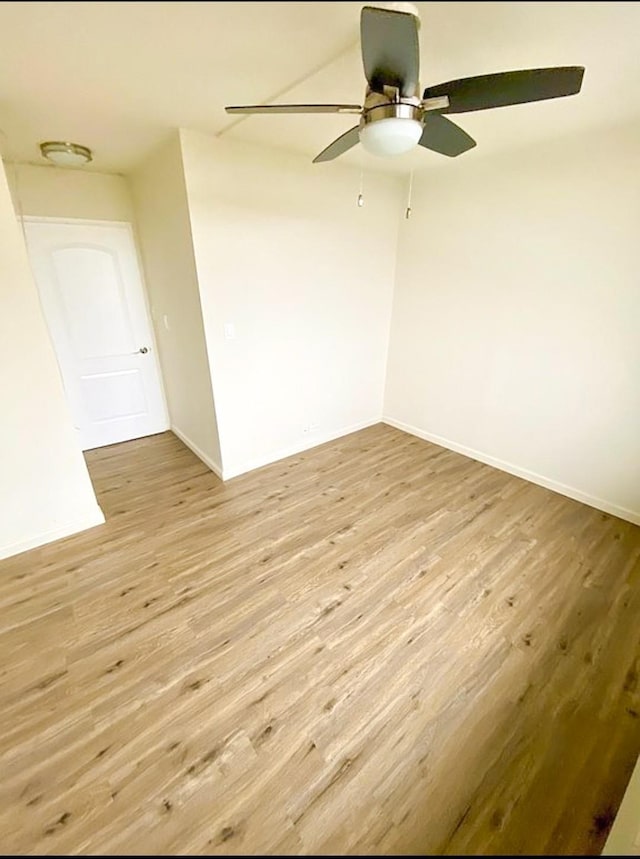 spare room with light wood-style floors and baseboards