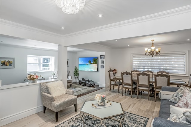 living area featuring light wood finished floors, baseboards, crown molding, a chandelier, and recessed lighting