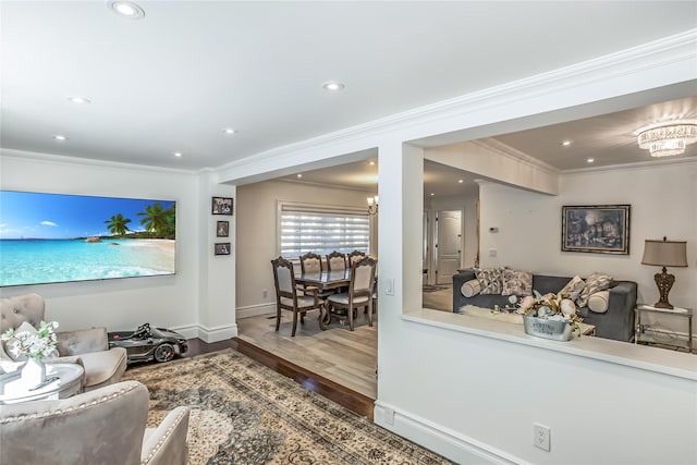 living area with a chandelier, recessed lighting, wood finished floors, baseboards, and crown molding