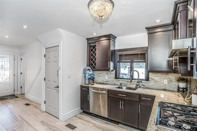 kitchen with dishwasher, light stone counters, a sink, gas stovetop, and backsplash