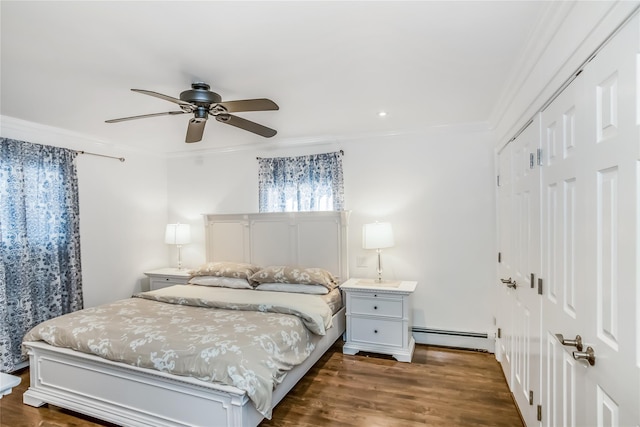 bedroom with a baseboard radiator, ceiling fan, ornamental molding, dark wood-style flooring, and a closet