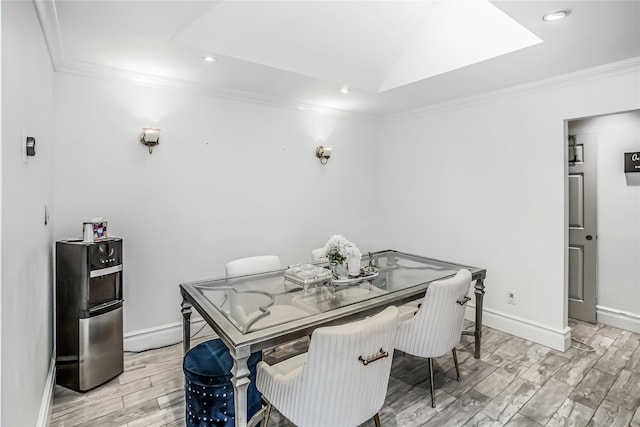 dining space featuring baseboards, wood finish floors, and crown molding