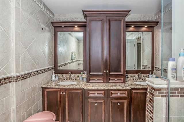 full bathroom featuring a sink, tile walls, and double vanity