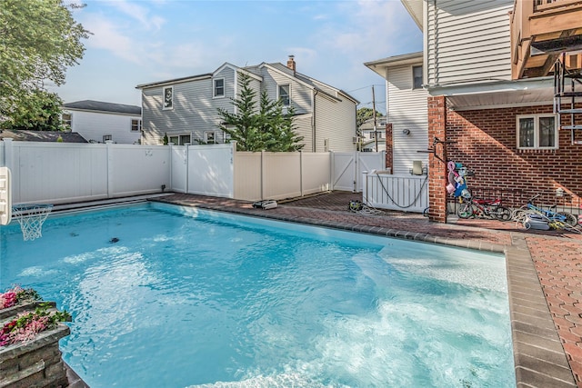 view of swimming pool with a gate, a fenced backyard, and a fenced in pool