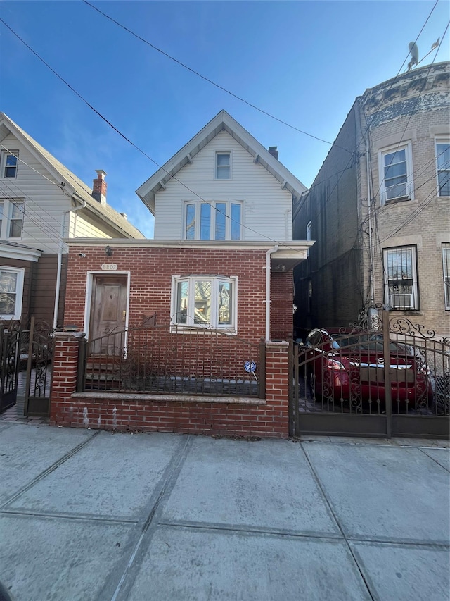 view of front of house featuring a gate, brick siding, and fence