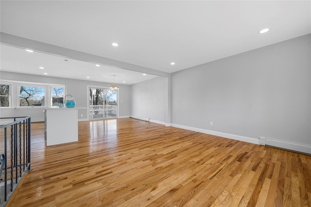 unfurnished living room featuring light wood finished floors, baseboards, a baseboard heating unit, and recessed lighting