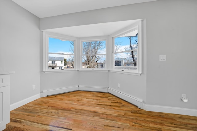 spare room featuring light wood-style flooring and baseboards