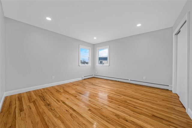 interior space featuring baseboards, baseboard heating, wood finished floors, and recessed lighting