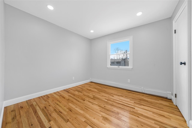 unfurnished bedroom featuring light wood finished floors, a baseboard radiator, baseboards, and recessed lighting