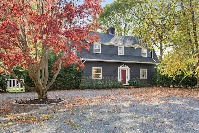 view of front of home featuring a shingled roof and a chimney