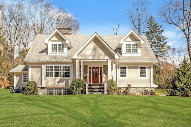 view of front facade with a chimney, a front lawn, and roof with shingles