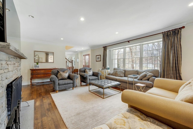 living area with a fireplace, crown molding, recessed lighting, dark wood-type flooring, and stairs