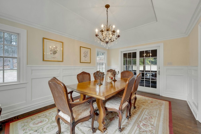 dining space with dark wood-style floors, a chandelier, a healthy amount of sunlight, and crown molding